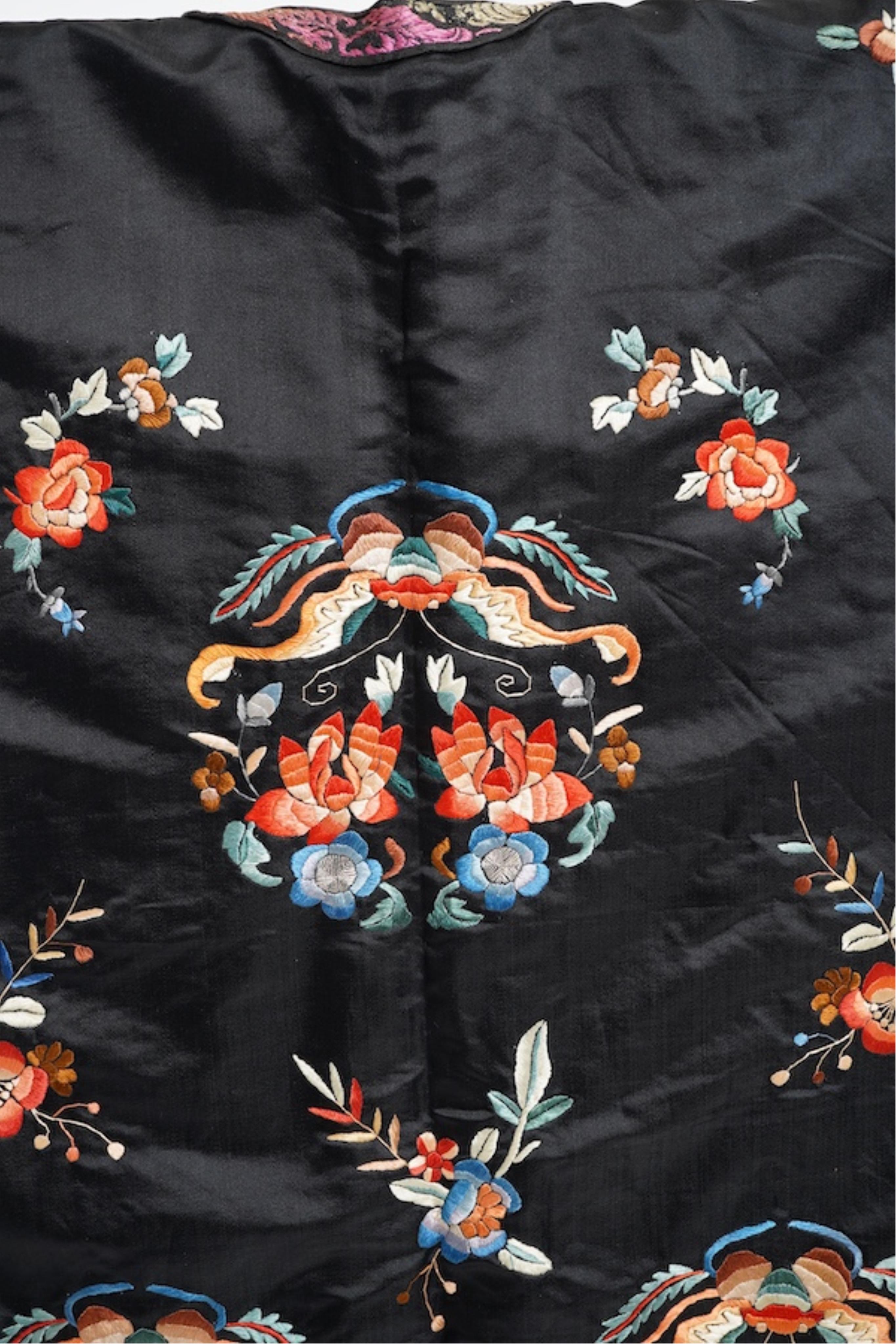 A late 19th early 20th century Chinese black silk polychrome embroidered ladies robe, decorated with cream silk, gilt and Peking knot bordered sleeve bands. The sleeve bands worked with fine figural and other embroidered